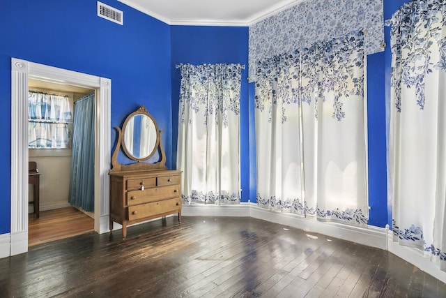 bedroom featuring crown molding and dark wood-type flooring