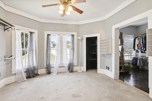 interior space with crown molding and ceiling fan