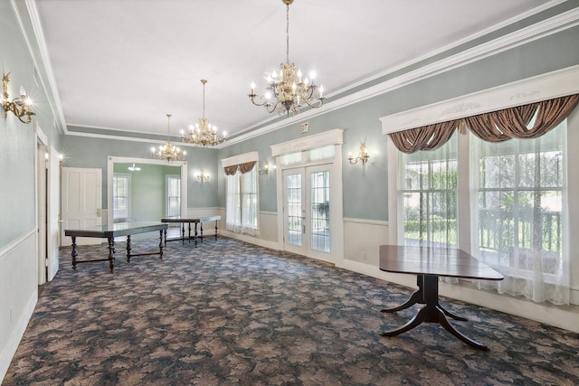 unfurnished dining area featuring french doors, plenty of natural light, a notable chandelier, and ornamental molding