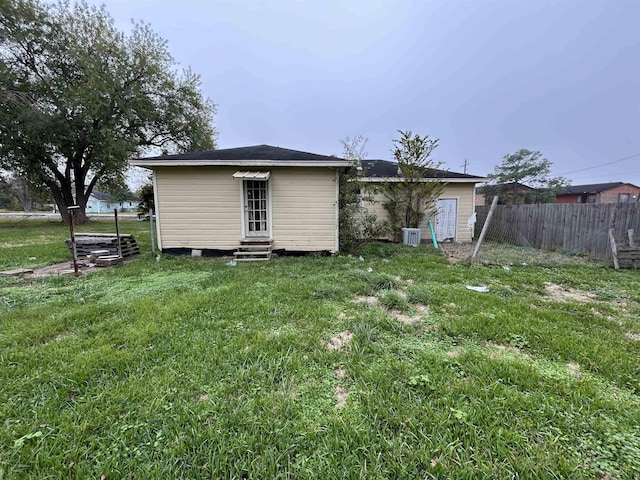 rear view of property featuring a lawn