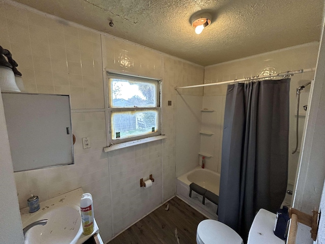 full bathroom with toilet, hardwood / wood-style floors, tile walls, a textured ceiling, and sink