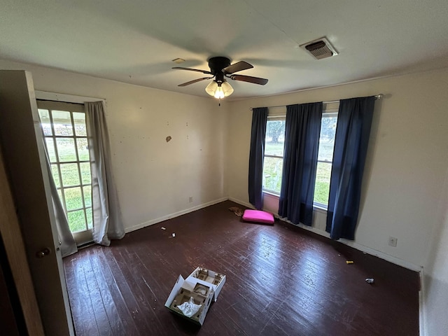 unfurnished room featuring dark hardwood / wood-style floors, ceiling fan, and plenty of natural light