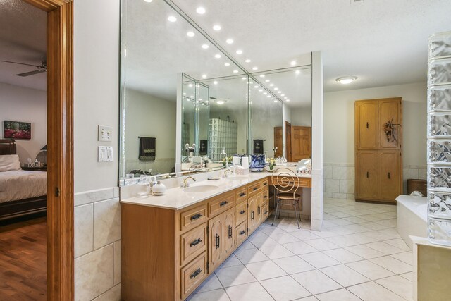 bathroom featuring vanity, tile patterned floors, ceiling fan, and tile walls