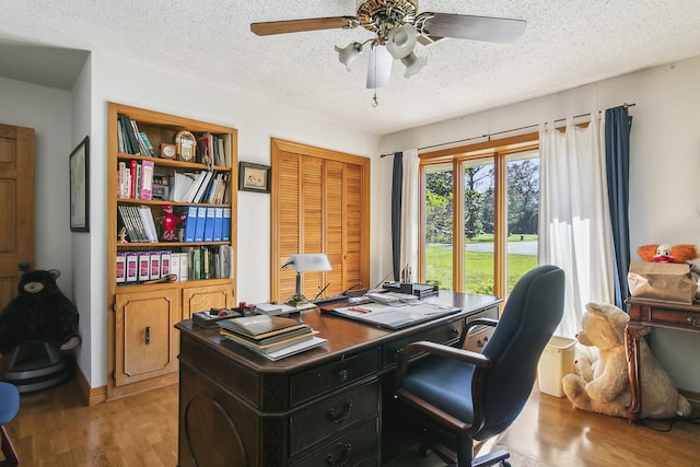 home office with ceiling fan, a textured ceiling, and light wood-type flooring