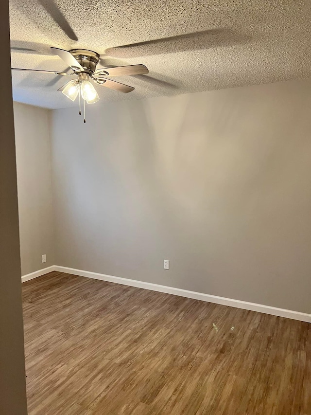 2210 N St, Beaumont, TX 77701 - empty room featuring dark hardwood / wood-style floors, ceiling fan, and a textured ceiling