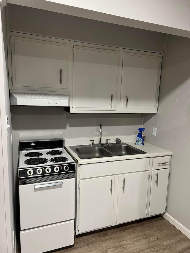2210 N St, Beaumont, TX 77701 - kitchen with electric range, white cabinetry, dark wood-type flooring, and sink