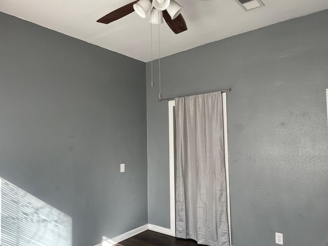 empty room with ceiling fan and dark hardwood / wood-style floors