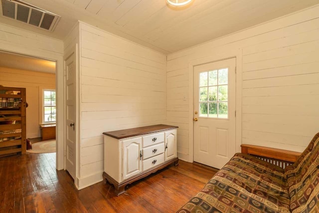 living area with wooden walls, dark hardwood / wood-style flooring, and a healthy amount of sunlight