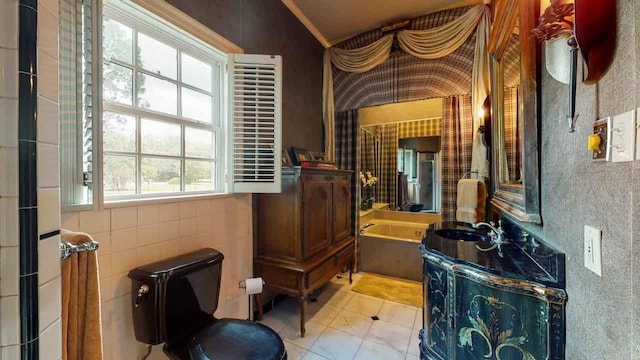 bathroom with tile patterned floors, vanity, toilet, and a tub