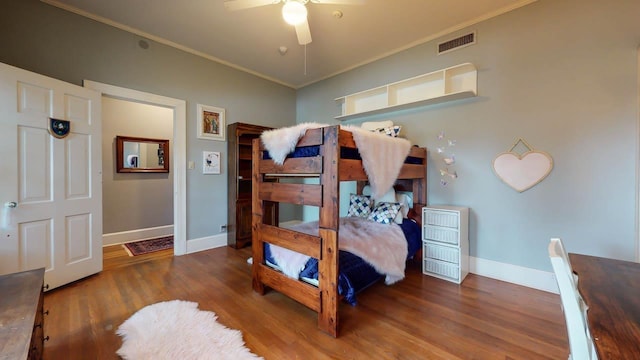 bedroom featuring ceiling fan, dark hardwood / wood-style floors, and ornamental molding