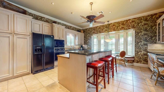 kitchen featuring black appliances, a kitchen breakfast bar, a kitchen island, and crown molding