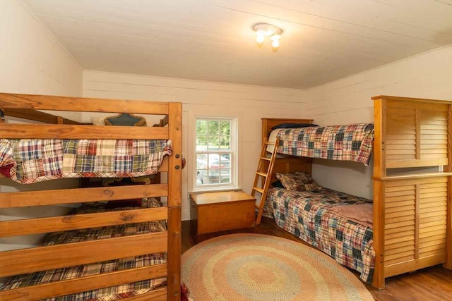 bedroom featuring wood walls and hardwood / wood-style floors