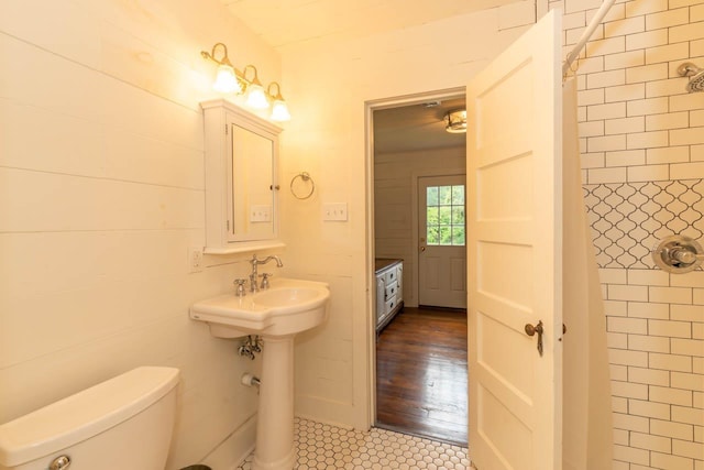 bathroom featuring tile patterned flooring, toilet, and walk in shower