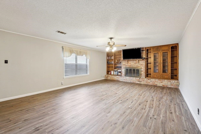 5960 Navajo Trl, Beaumont, TX 77708 - unfurnished living room featuring a textured ceiling, crown molding, wood finished floors, baseboards, and a ceiling fan