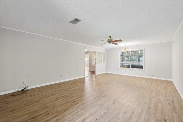 5960 Navajo Trl, Beaumont, TX 77708 - unfurnished living room featuring a chandelier, a textured ceiling, light wood finished floors, ornamental molding, and baseboards