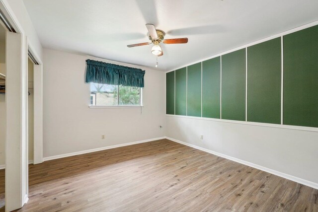 5960 Navajo Trl, Beaumont, TX 77708 - unfurnished bedroom featuring wood finished floors, baseboards, a ceiling fan, and a closet
