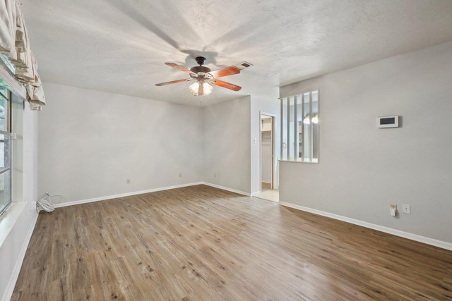 5960 Navajo Trl, Beaumont, TX 77708 - spare room featuring ceiling fan, healthy amount of natural light, wood finished floors, a textured ceiling, and baseboards