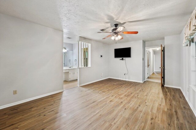 5960 Navajo Trl, Beaumont, TX 77708 - unfurnished living room featuring ceiling fan, wood finished floors, baseboards, and a textured ceiling