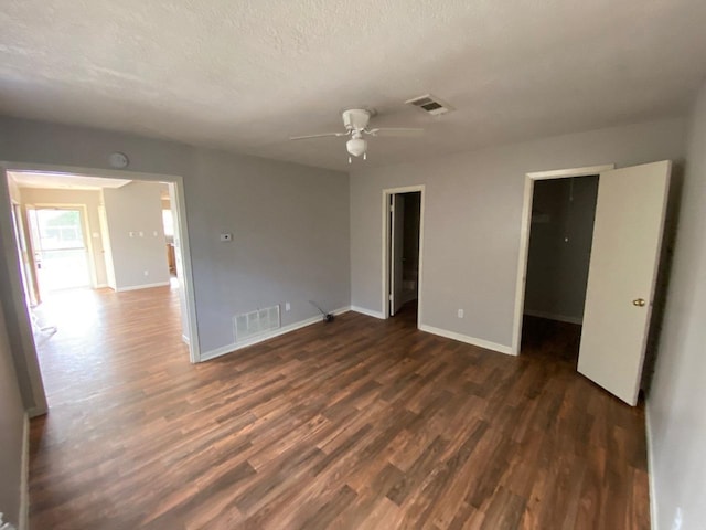 unfurnished room with a textured ceiling, dark hardwood / wood-style flooring, and ceiling fan