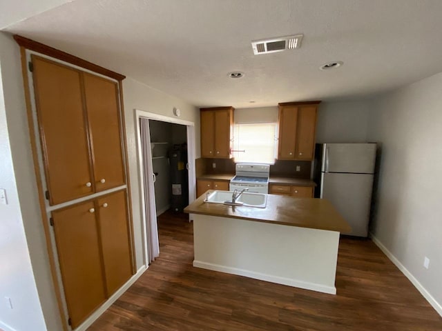 kitchen featuring white range oven, a kitchen island with sink, sink, dark hardwood / wood-style floors, and stainless steel refrigerator