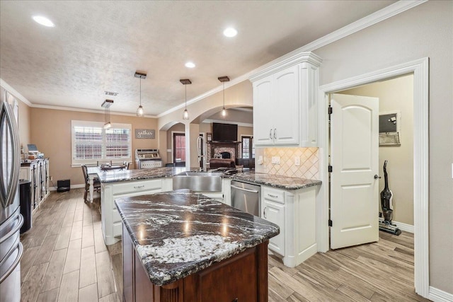3113 Labrador Ln, Port Neches, TX 77651 - kitchen featuring stainless steel dishwasher, a sink, a peninsula, a center island, and arched walkways