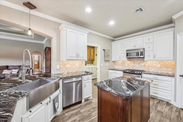3113 Labrador Ln, Port Neches, TX 77651 - kitchen featuring visible vents, arched walkways, separate washer and dryer, a sink, and stainless steel appliances