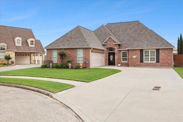 3113 Labrador Ln, Port Neches, TX 77651 - view of front of house with brick siding, a shingled roof, a front lawn, and concrete driveway