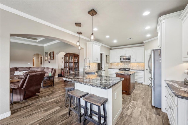 3113 Labrador Ln, Port Neches, TX 77651 - kitchen with arched walkways, stainless steel appliances, open floor plan, decorative backsplash, and ornamental molding