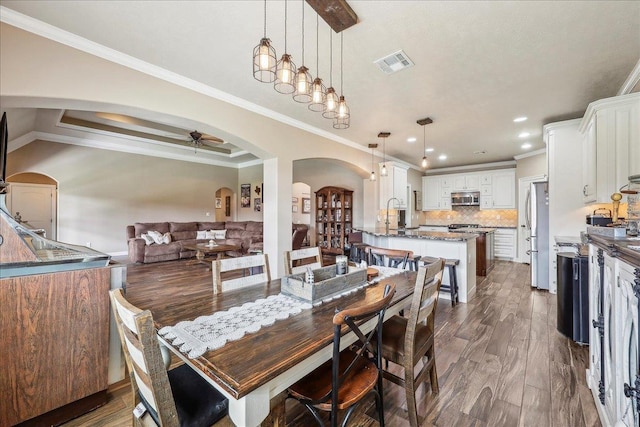 3113 Labrador Ln, Port Neches, TX 77651 - dining space featuring visible vents, arched walkways, a ceiling fan, and dark wood-style floors