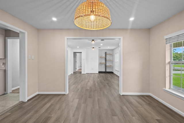 unfurnished dining area with wood finished floors, baseboards, recessed lighting, and a ceiling fan