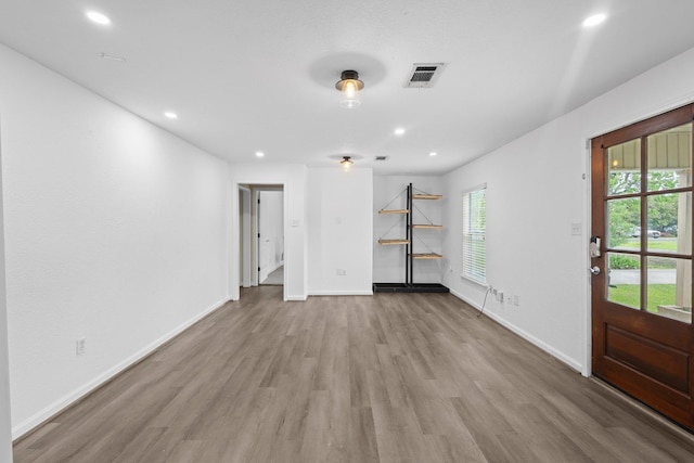 unfurnished living room featuring baseboards, wood finished floors, visible vents, and recessed lighting