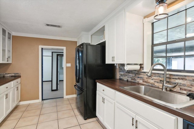 kitchen featuring light tile patterned flooring, white cabinetry, sink, and tasteful backsplash