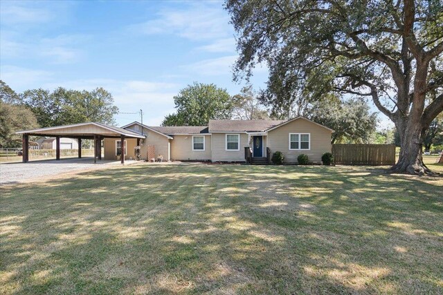 ranch-style home featuring a front lawn and a carport