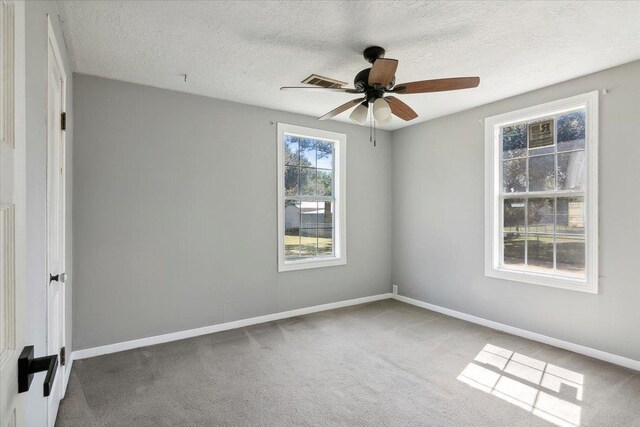 spare room featuring a textured ceiling, carpet floors, and ceiling fan