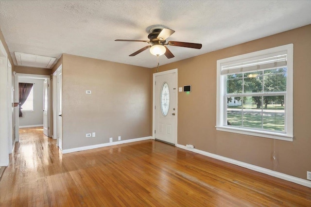 foyer featuring ceiling fan, light hardwood / wood-style floors, and a textured ceiling