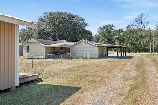 back of house with a carport and a yard