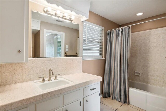 bathroom with decorative backsplash, shower / tub combo with curtain, vanity, and tile patterned flooring