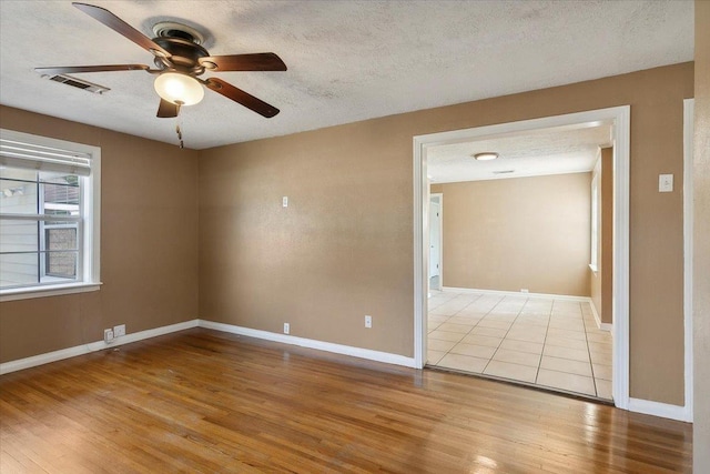 spare room featuring ceiling fan, a textured ceiling, and light hardwood / wood-style flooring