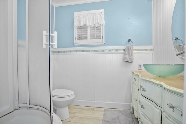 bathroom featuring tile patterned flooring, vanity, toilet, and ornamental molding