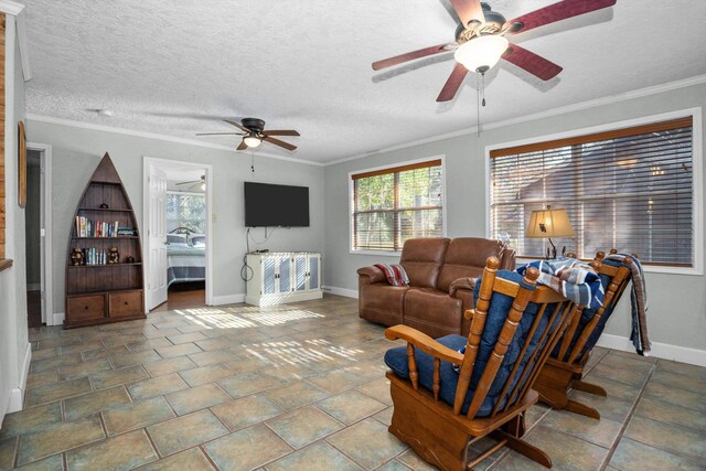 living room with ceiling fan, a textured ceiling, and ornamental molding