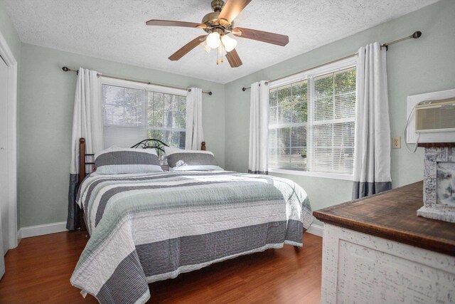 bedroom featuring multiple windows, ceiling fan, and dark hardwood / wood-style floors