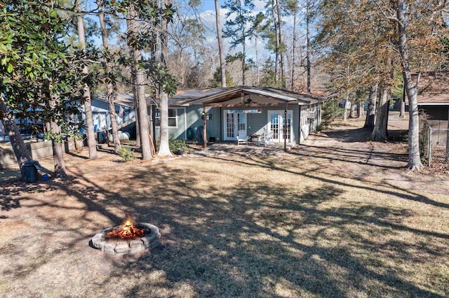 rear view of property featuring a fire pit