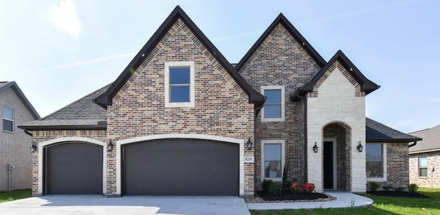 french provincial home featuring brick siding, an attached garage, and driveway