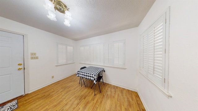 1005 Black Walnut Ln, Jasper, TX 75951 - interior space featuring a textured ceiling, baseboards, a notable chandelier, and light wood-type flooring
