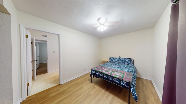 1005 Black Walnut Ln, Jasper, TX 75951 - bedroom featuring baseboards, a textured ceiling, and wood finished floors