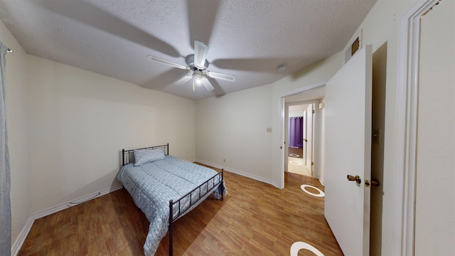 1005 Black Walnut Ln, Jasper, TX 75951 - bedroom featuring light wood-style floors, a textured ceiling, ceiling fan, and baseboards
