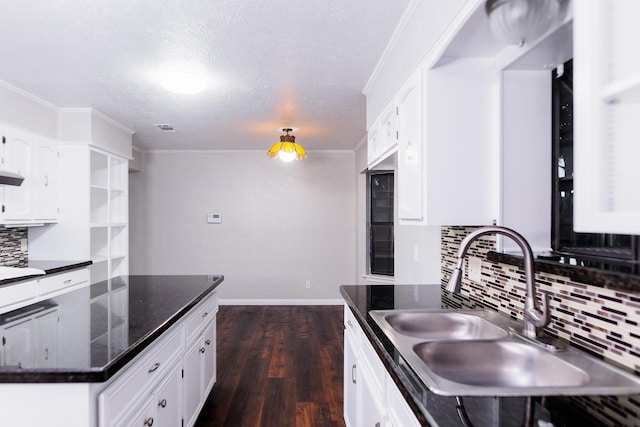 kitchen with sink, a textured ceiling, dark stone countertops, white cabinets, and backsplash