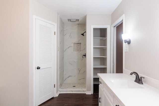 bathroom with vanity, tiled shower, and hardwood / wood-style floors