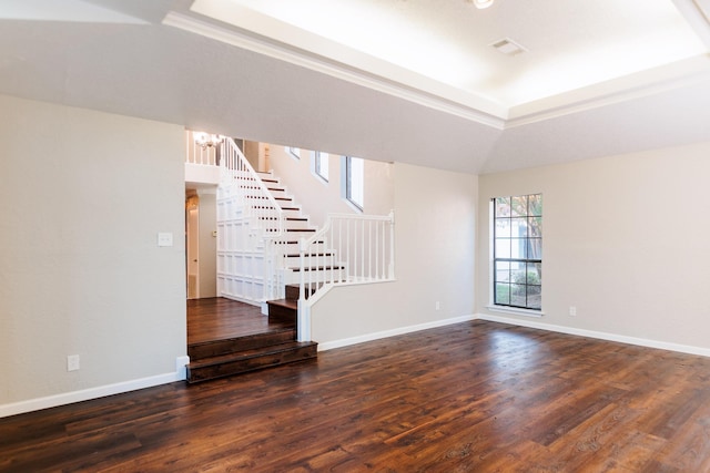 unfurnished living room with a tray ceiling, dark hardwood / wood-style flooring, and a notable chandelier