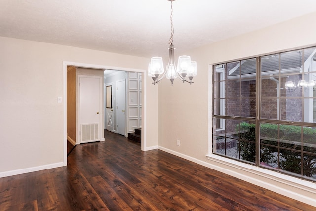 unfurnished dining area with dark hardwood / wood-style flooring and a notable chandelier